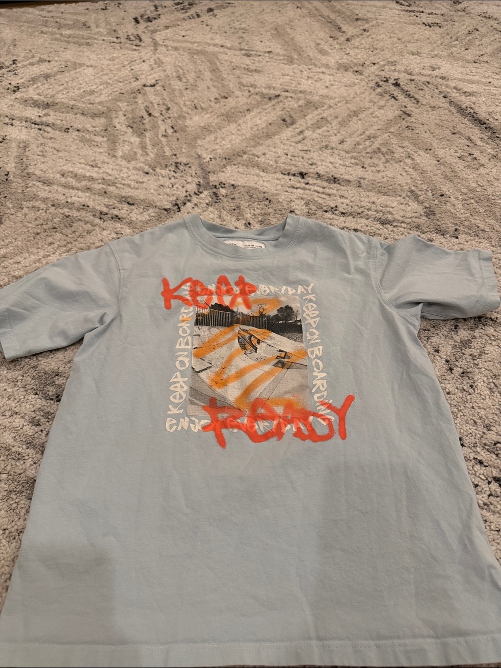 Zara Light Blue Skateboard Graphic Tee with Orange Accents